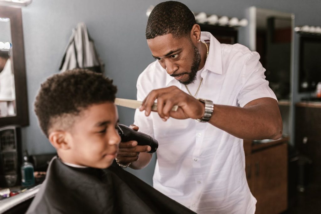 The Art of Drawing Readers In: Your attractive post title goes here Barber in a white shirt carefully trimming a boy's hair at a salon.